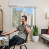 Resident working on his laptop and talking on the phone in his apartment home