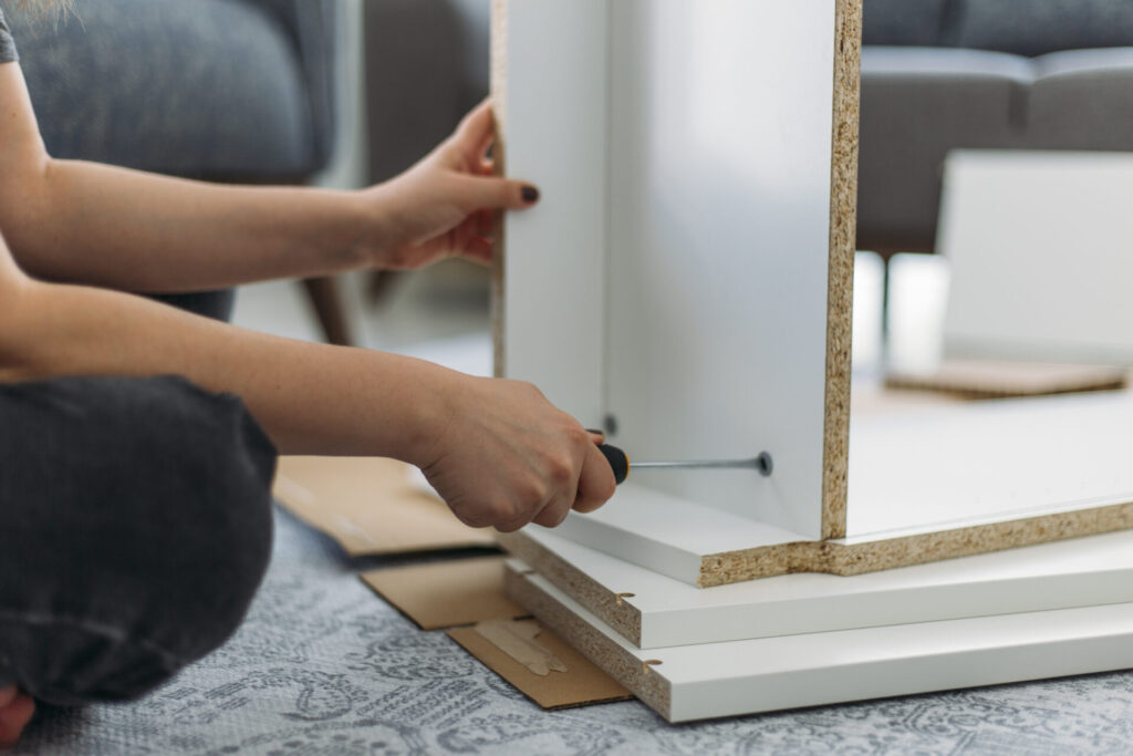 Person assembling furniture with a tool