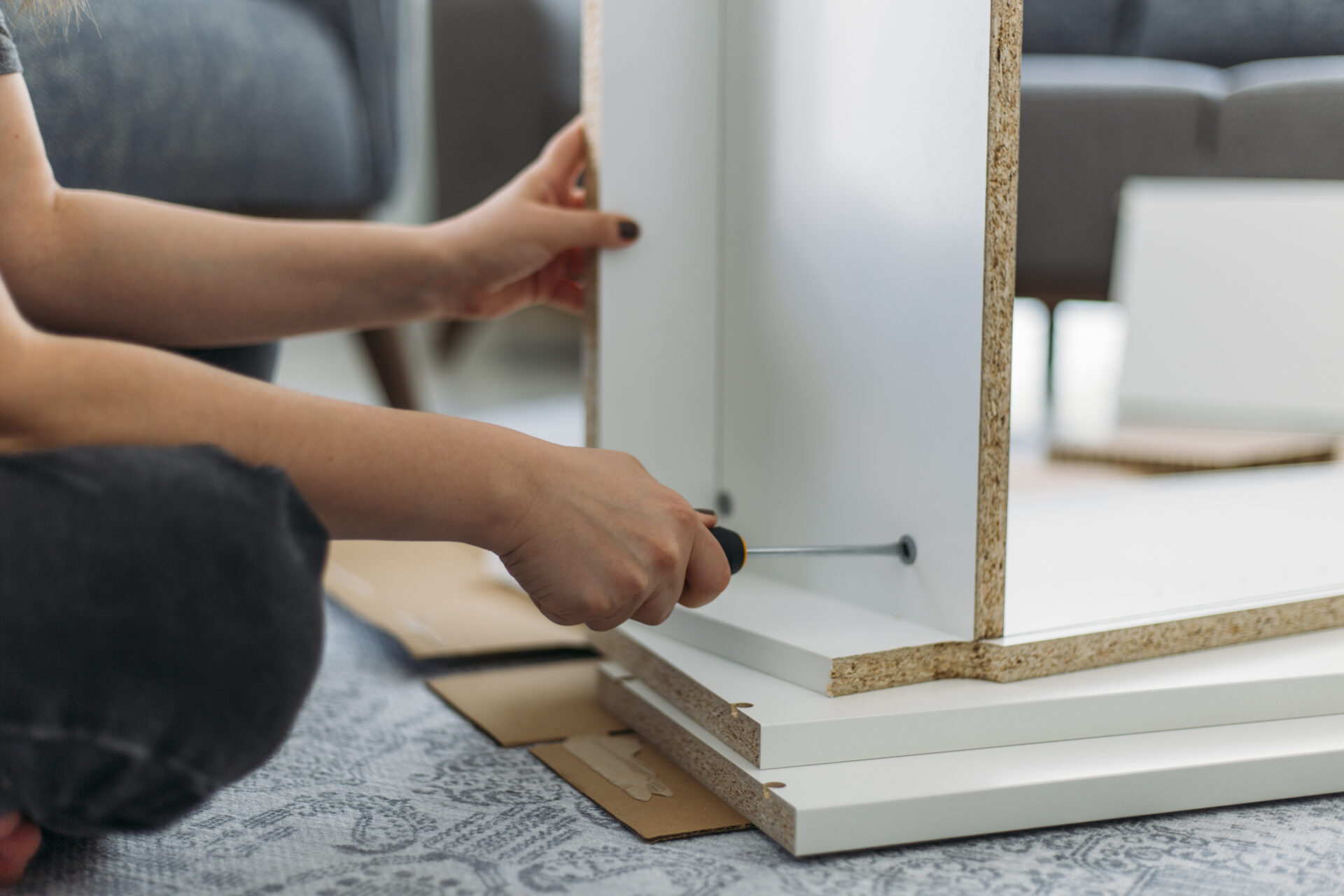 Person assembling furniture with a tool