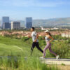 Two people jogging with Irvine in the background