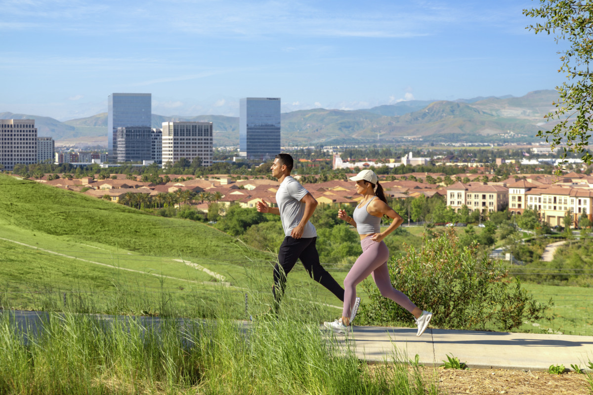 Two people jogging with Irvine in the background