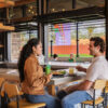 Man and woman sitting at restaurant with The Market Place signage behind them.