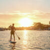 Man paddles boards at sunset near Newport Beach Marina